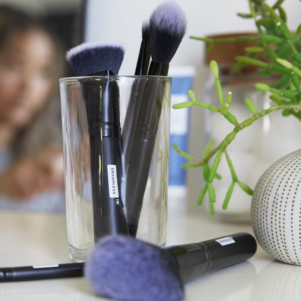 Lifestyle, set of brandless makeup brushes on a bathroom counter and in a glass container.