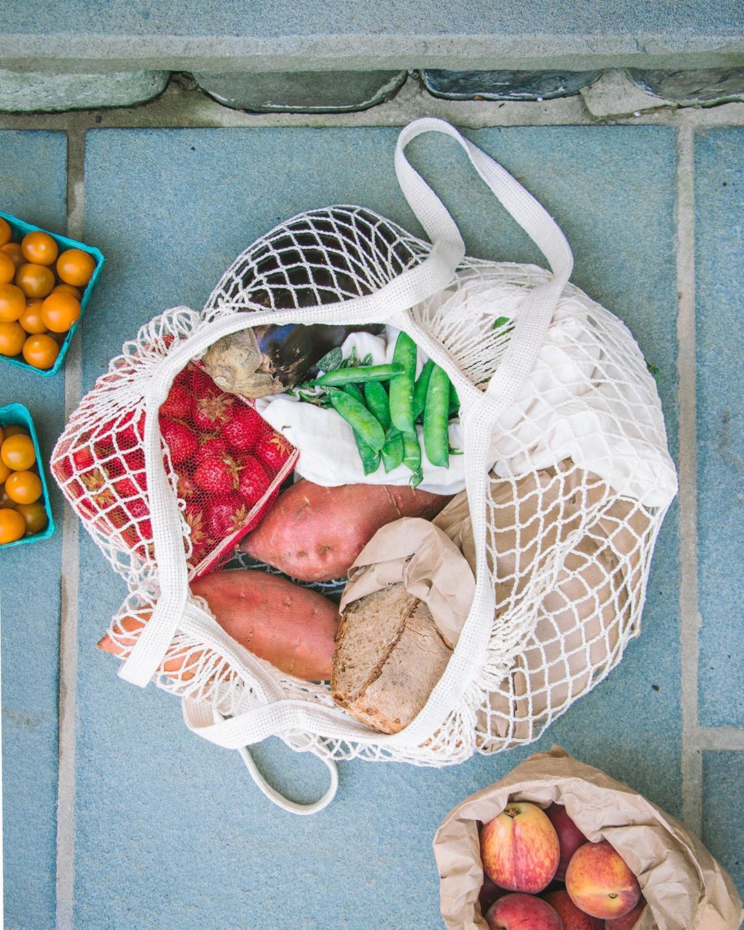 Top view, net market tote full of fresh veggies purhcased from a local farmer's market.