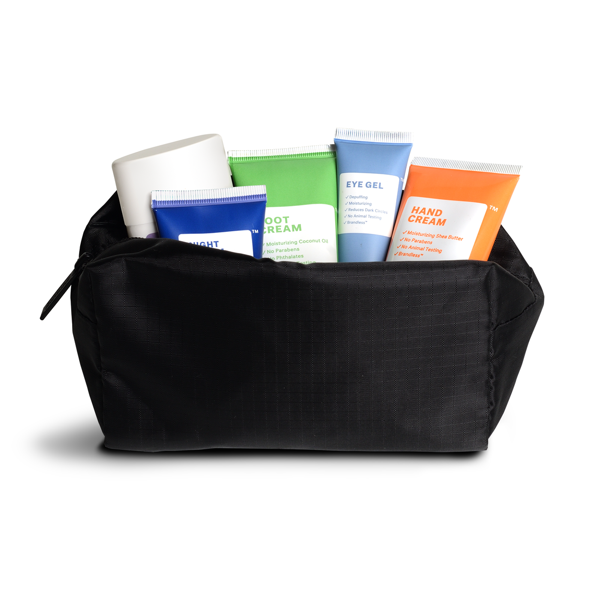 Lifestyle.  Side view of travel pouch, zipped open, showing 5 different brandlesss personal care items poling out the top, demonstrating the large storage capacity of the bag.