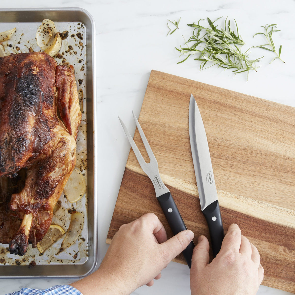 Lifestyle photo, man&#39;s hands reaching for a carving knive and carving fork sitting on a cuttong board nex to a roasted chicken on a pan just out of the oven.