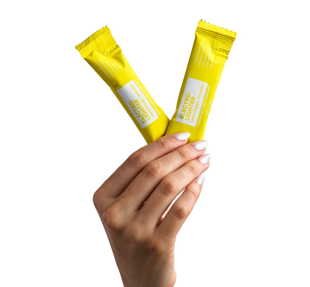 Electro-Llighter Energy + Hydration. 100% Vitamin C. B Vitamin Boost. 10 Calories. 100mg Caffeine. Brandless. Natural Lemon Flavor Drink Mix. Dietary Supplement. 5.5g per serving | 30 servings. Front of pouch and two single serving stick packs.